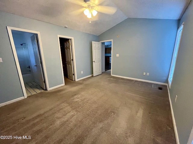 unfurnished bedroom featuring ensuite bathroom, lofted ceiling, carpet floors, ceiling fan, and a textured ceiling