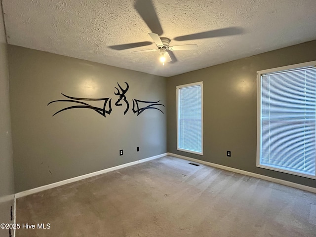 carpeted empty room with a textured ceiling and ceiling fan