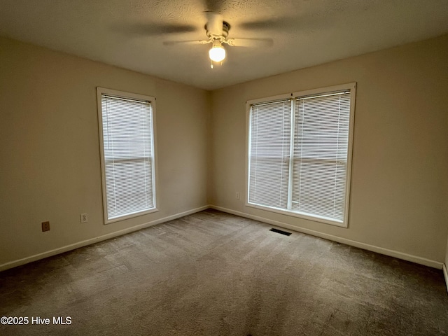 carpeted spare room featuring ceiling fan