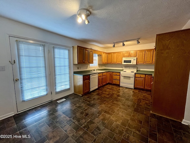 kitchen with white appliances, sink, and a textured ceiling