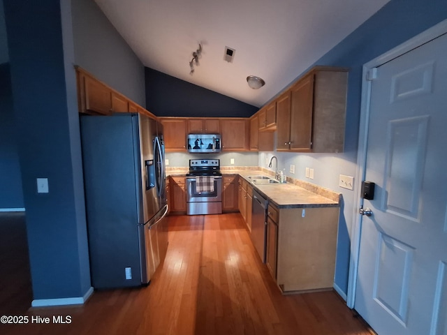 kitchen with lofted ceiling, sink, light hardwood / wood-style floors, and appliances with stainless steel finishes