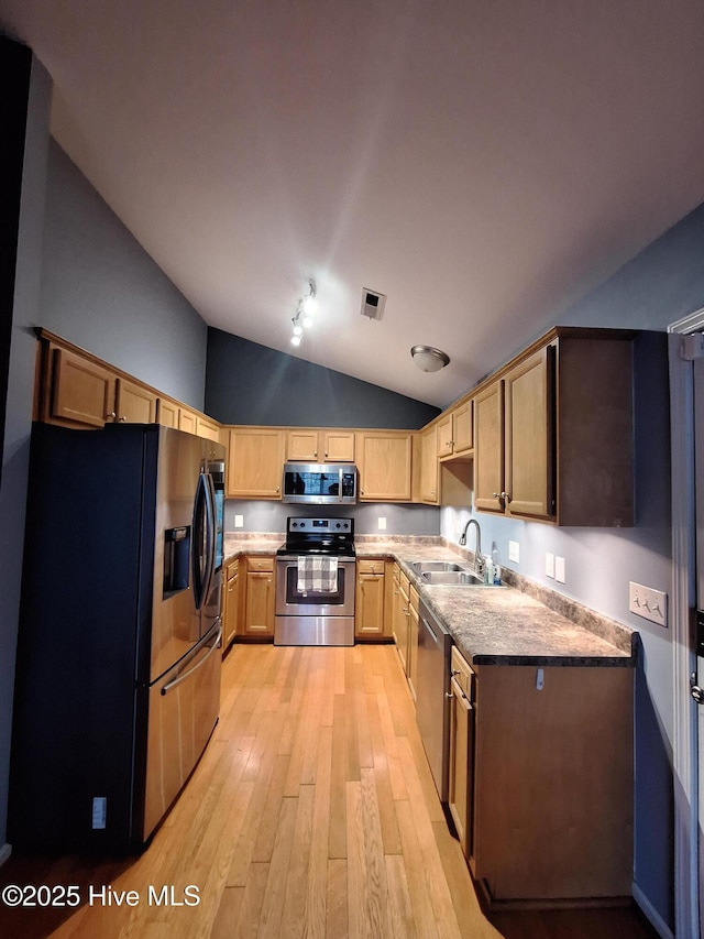 kitchen with lofted ceiling, sink, light hardwood / wood-style floors, and appliances with stainless steel finishes