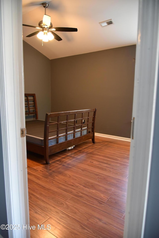 bedroom featuring wood-type flooring and vaulted ceiling