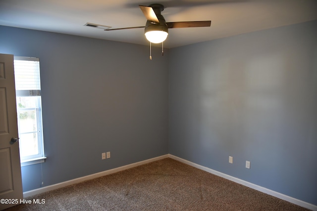 empty room featuring ceiling fan and carpet