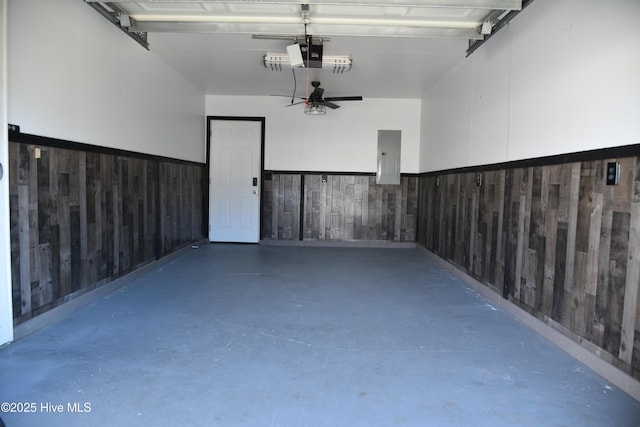 garage featuring a garage door opener, wooden walls, and electric panel