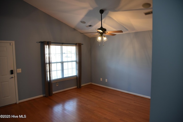 empty room featuring hardwood / wood-style flooring, ceiling fan, and vaulted ceiling