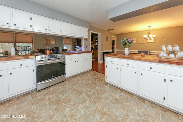 kitchen with an inviting chandelier, butcher block countertops, hanging light fixtures, and electric range