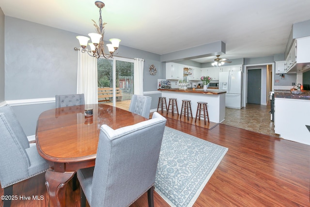 dining room featuring dark hardwood / wood-style flooring and ceiling fan with notable chandelier