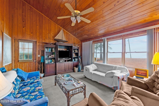 carpeted living room with vaulted ceiling, ceiling fan, wood ceiling, and wood walls