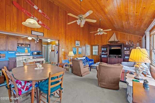 carpeted dining space featuring wooden walls, high vaulted ceiling, and wooden ceiling