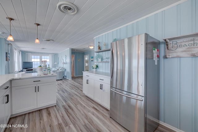 kitchen featuring pendant lighting, white cabinetry, stainless steel fridge, light hardwood / wood-style floors, and wood ceiling