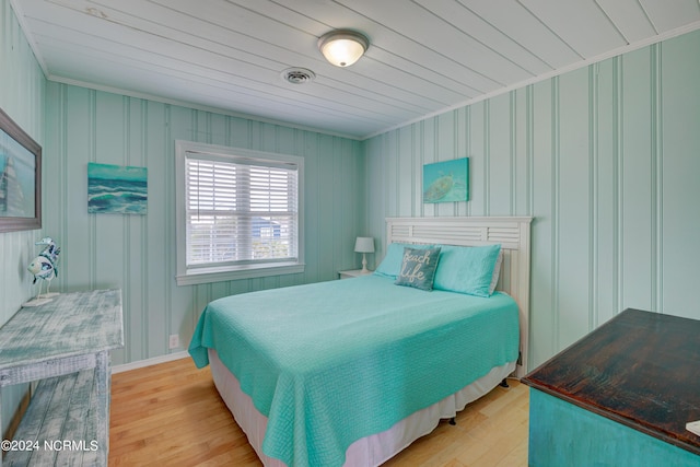 bedroom featuring crown molding and light hardwood / wood-style flooring