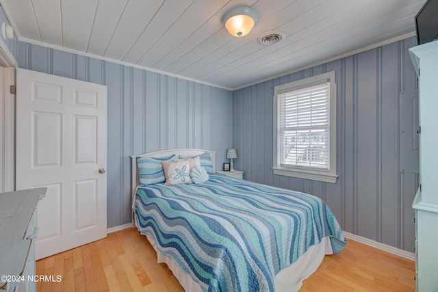 bedroom featuring wood ceiling, ornamental molding, and light hardwood / wood-style flooring