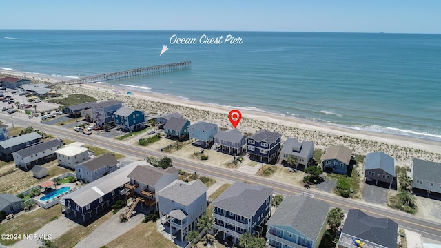 birds eye view of property with a water view and a beach view