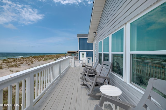 wooden terrace with a water view and a beach view