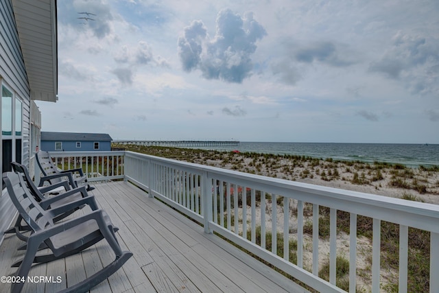 deck featuring a view of the beach and a water view