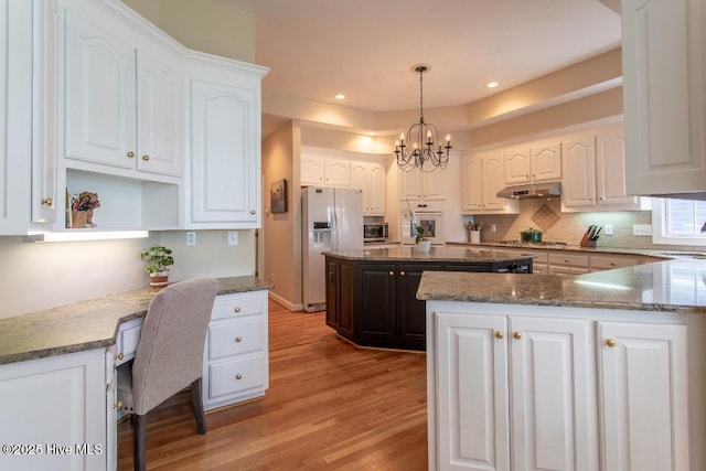 kitchen featuring white cabinetry, hanging light fixtures, and stainless steel appliances