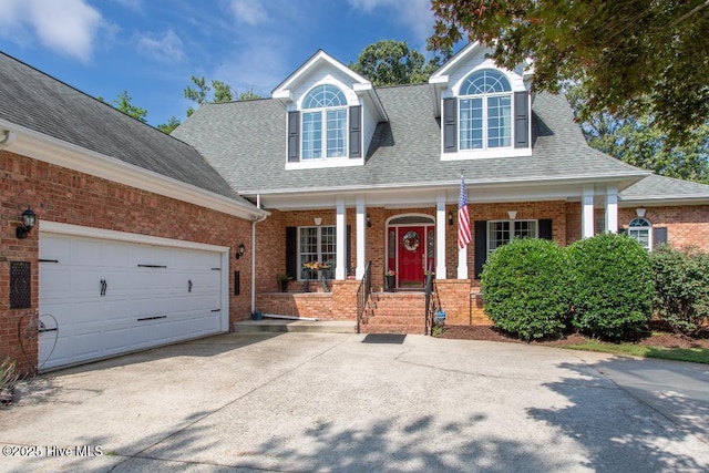 cape cod house with a garage and covered porch