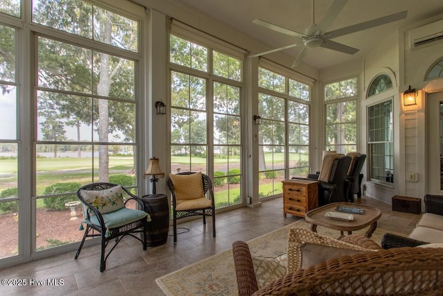 sunroom / solarium with a healthy amount of sunlight, a wall mounted AC, and ceiling fan