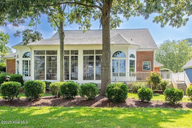 view of front of property featuring a wooden deck and a front lawn