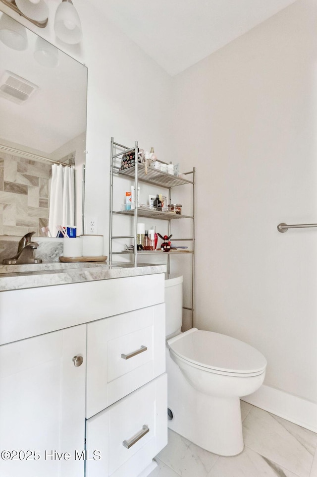 bathroom featuring vanity, curtained shower, and toilet