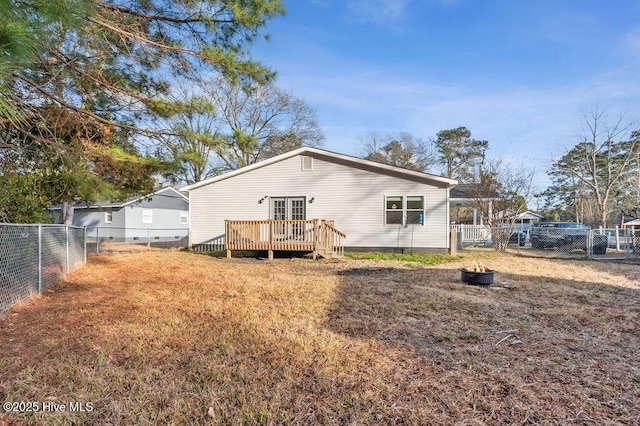 back of house with a deck and a lawn