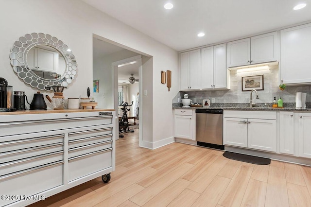 kitchen with backsplash, stainless steel dishwasher, white cabinets, and light wood-type flooring