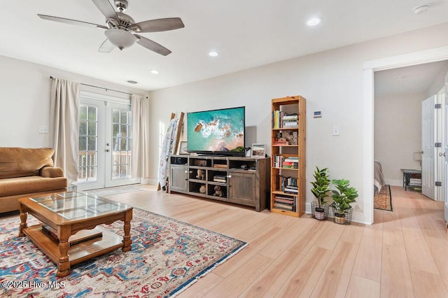 living room featuring french doors, ceiling fan, and light hardwood / wood-style floors