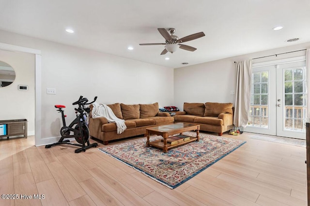 living room featuring french doors, ceiling fan, and light hardwood / wood-style flooring