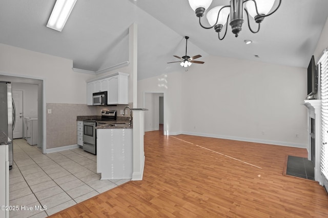 kitchen featuring appliances with stainless steel finishes, ceiling fan with notable chandelier, sink, white cabinets, and light wood-type flooring