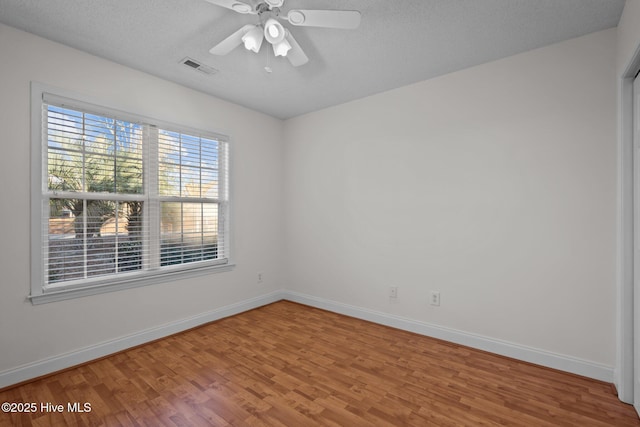 spare room featuring hardwood / wood-style flooring, ceiling fan, and a textured ceiling