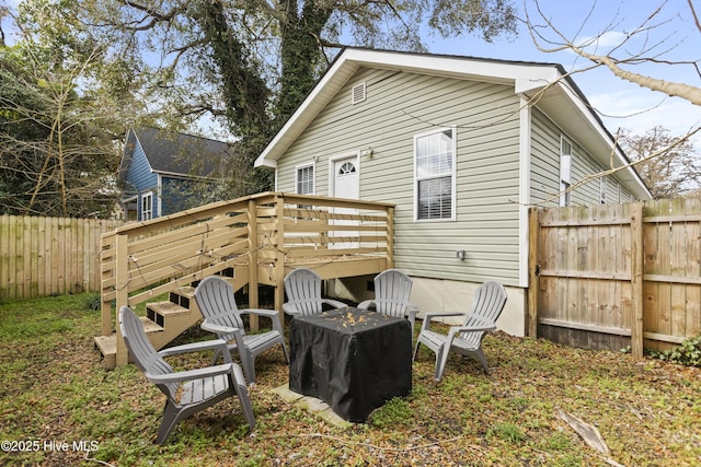 rear view of house featuring a wooden deck