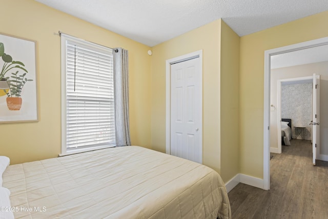 bedroom with dark hardwood / wood-style flooring and a textured ceiling