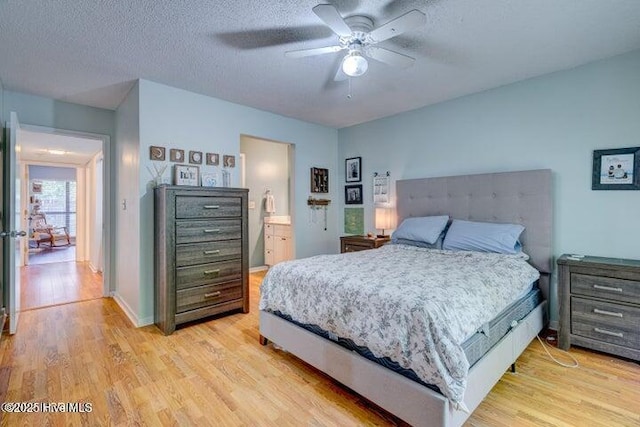 bedroom with connected bathroom, ceiling fan, light hardwood / wood-style floors, and a textured ceiling