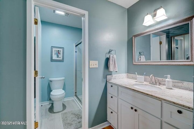 bathroom with vanity, toilet, a shower with door, and hardwood / wood-style floors