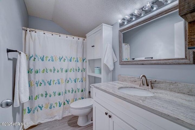 bathroom with hardwood / wood-style floors, lofted ceiling, vanity, toilet, and a textured ceiling