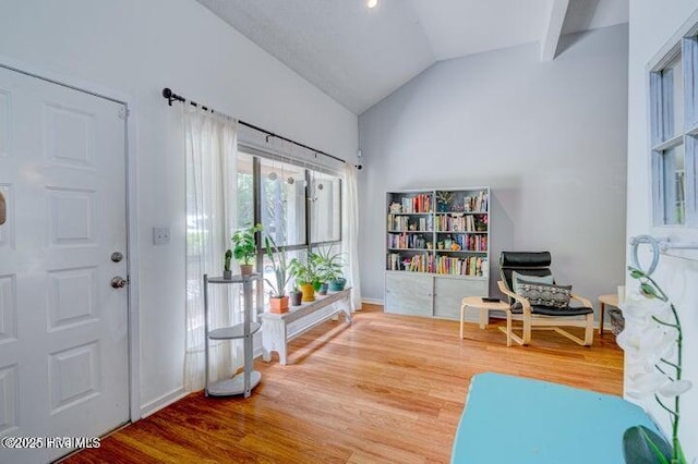 living area with hardwood / wood-style flooring and vaulted ceiling