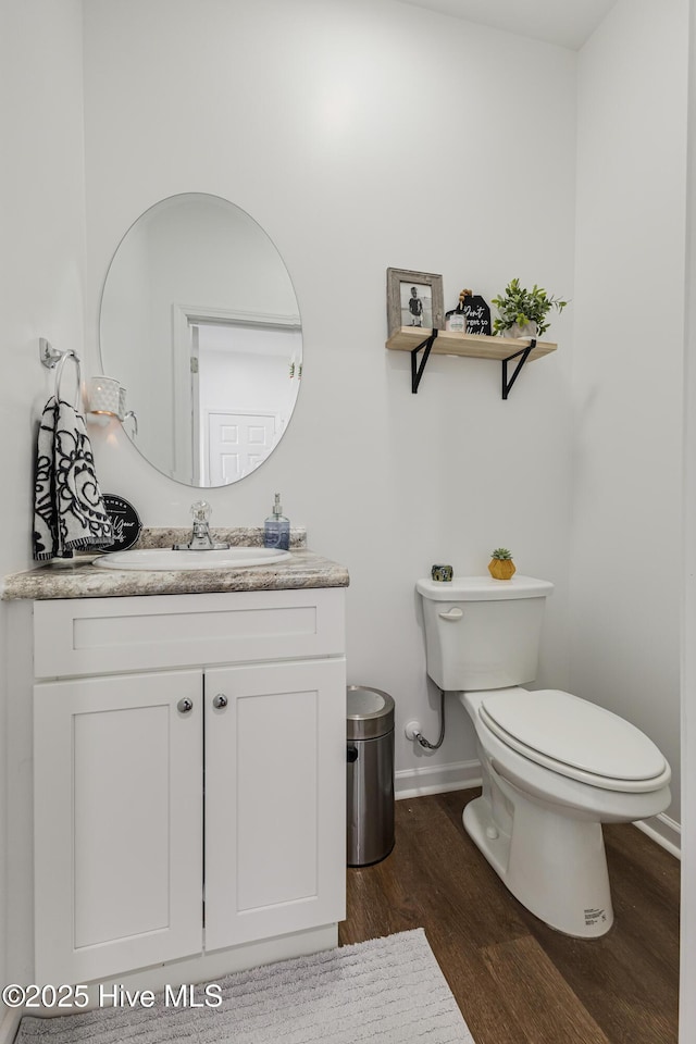 bathroom featuring vanity, toilet, and hardwood / wood-style floors