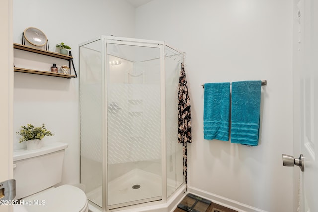 bathroom featuring an enclosed shower and toilet