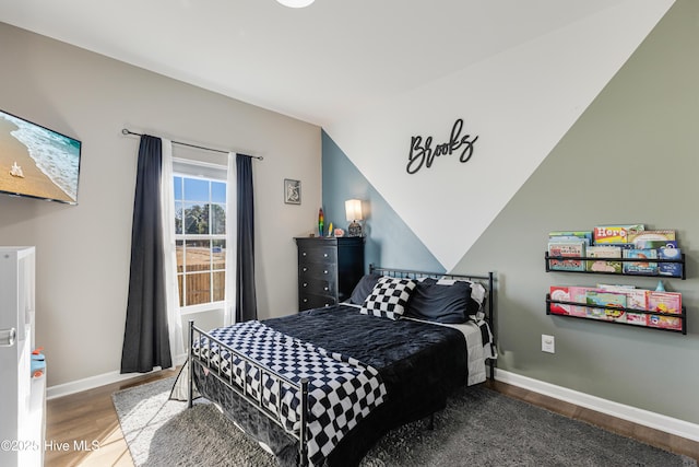 bedroom with hardwood / wood-style floors and vaulted ceiling