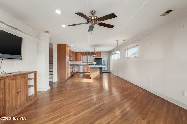 kitchen featuring visible vents, light wood-style flooring, brown cabinets, open floor plan, and pendant lighting