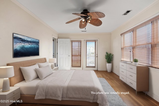 bedroom featuring visible vents, baseboards, access to outside, ornamental molding, and light wood-type flooring