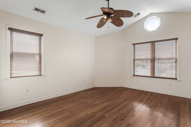 empty room with vaulted ceiling, visible vents, dark wood finished floors, and baseboards