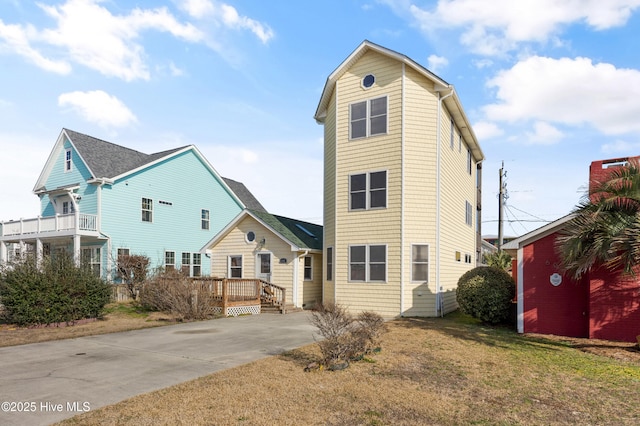 view of front facade featuring a wooden deck and a front lawn