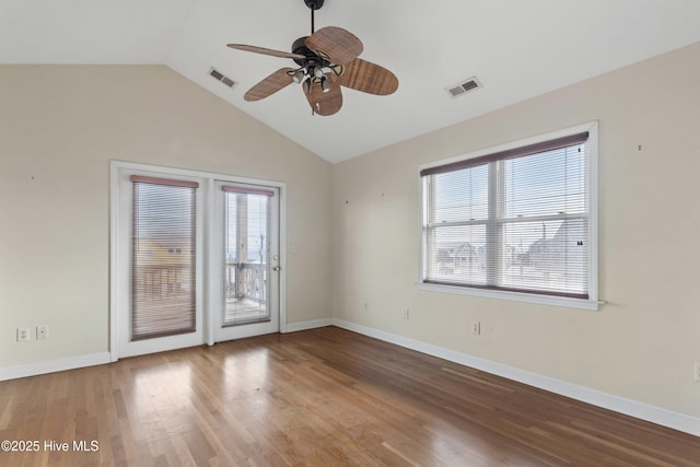 unfurnished room featuring vaulted ceiling, wood finished floors, visible vents, and baseboards