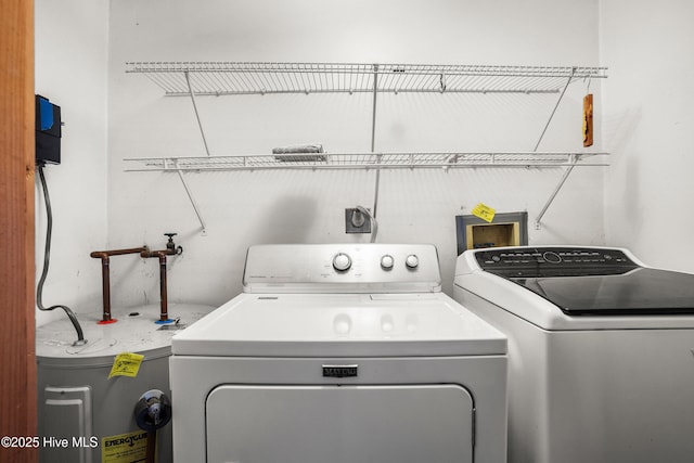 clothes washing area featuring laundry area, washer and dryer, and electric water heater