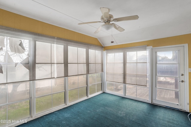 unfurnished sunroom featuring lofted ceiling, plenty of natural light, and ceiling fan