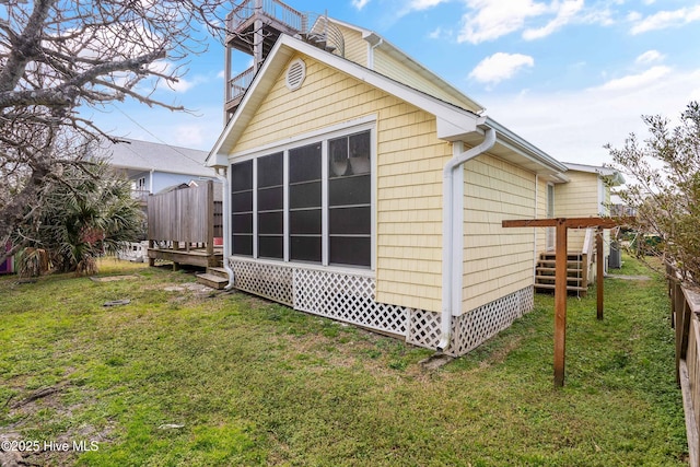 rear view of house featuring a lawn and fence