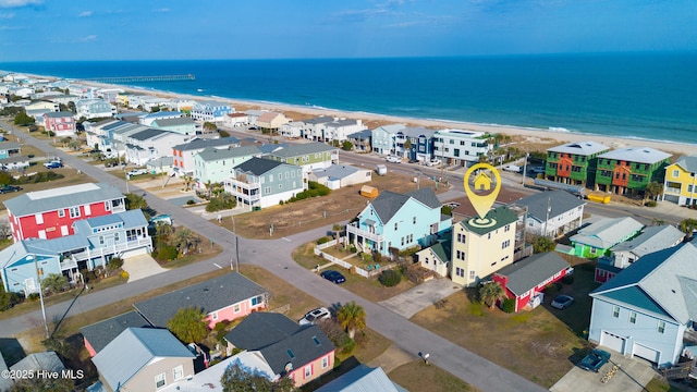 drone / aerial view featuring a residential view, a water view, and a beach view