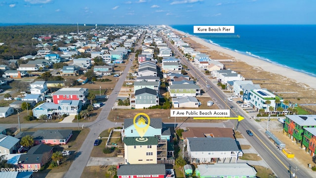 drone / aerial view featuring a water view, a residential view, and a view of the beach